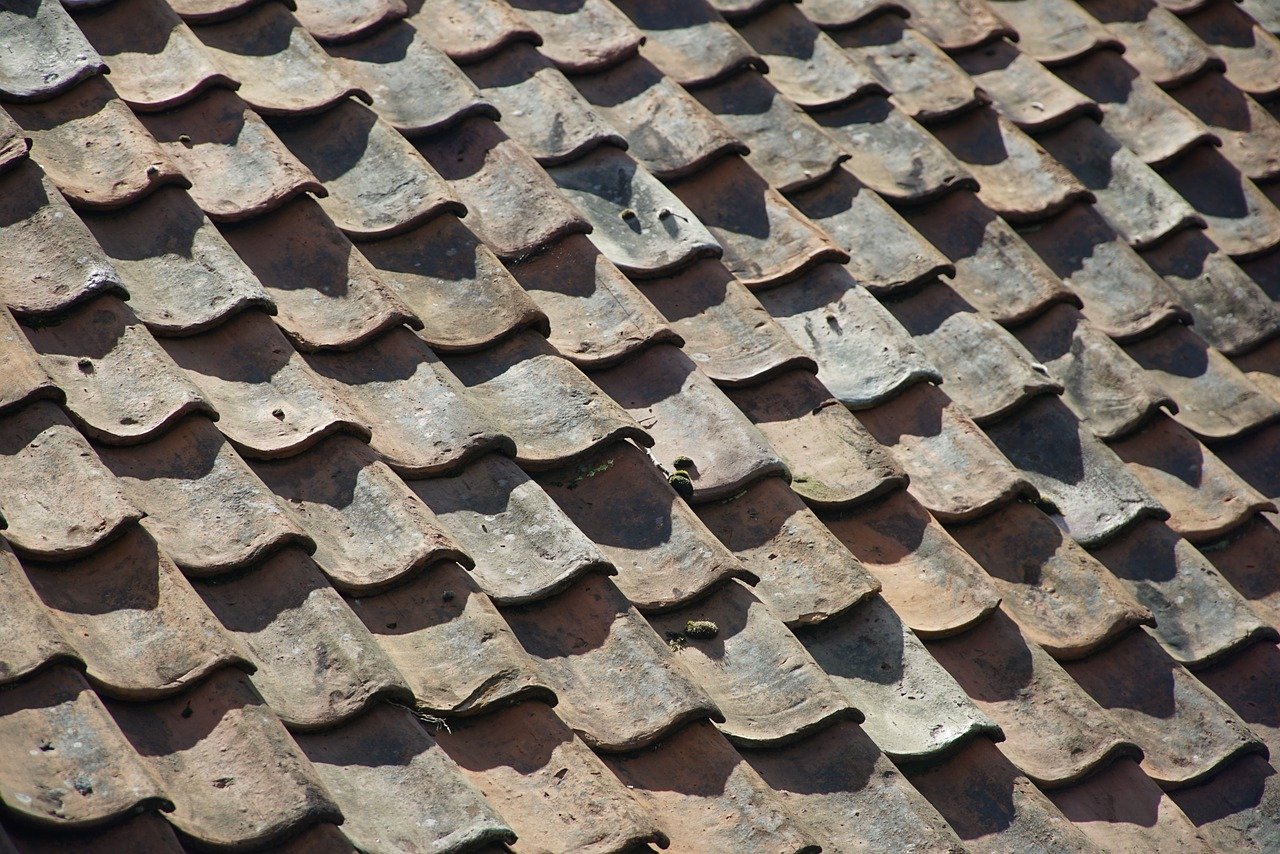 Curling and buckling tile shingles on a roof